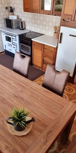 a kitchen with a wooden table with chairs and a table sidx sidx at Apartma Metka Bovec in Bovec