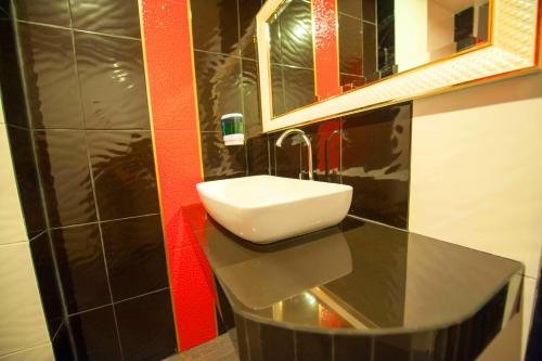 W łazience znajduje się umywalka i lustro. w obiekcie Dwella Suvarnabhumi w Lat Krabang