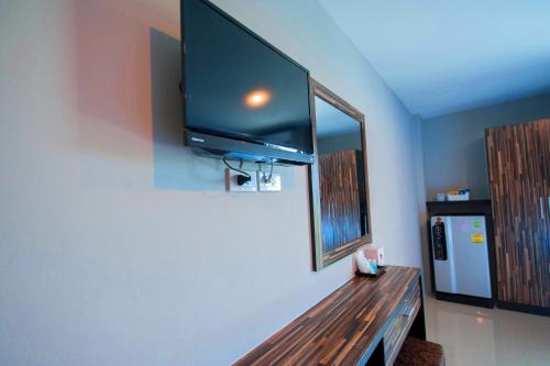 a room with a wooden bench with a tv on the wall at Dwella Suvarnabhumi in Lat Krabang