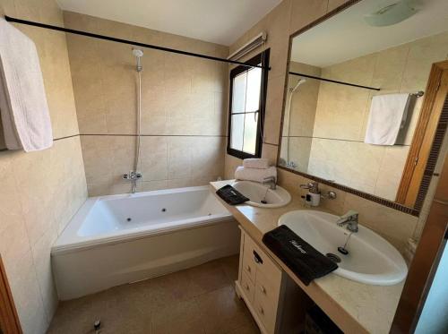 a bathroom with a tub and a sink and a tub and a mirror at Villa Eva - New to the market, fully refurbished licensed villa - private pool in Caleta De Fuste