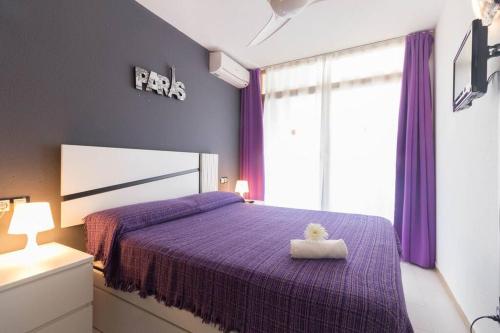 een slaapkamer met een paars bed met een teddybeer erop bij Complejo residencial-CAT 5 in Salou