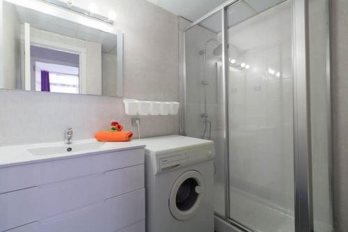 een badkamer met een wasmachine en een douche bij Complejo residencial-CAT 5 in Salou
