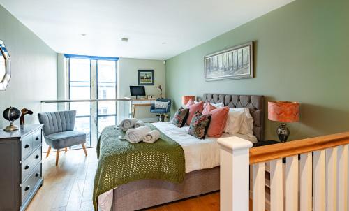 a bedroom with a bed and a desk and a chair at Stylish-Stays The Sanctuary, Stow-on-the-Wold -Luxurious Stylish, Grade II Listed Church conversion Workspace, centrally located in Stow on the Wold
