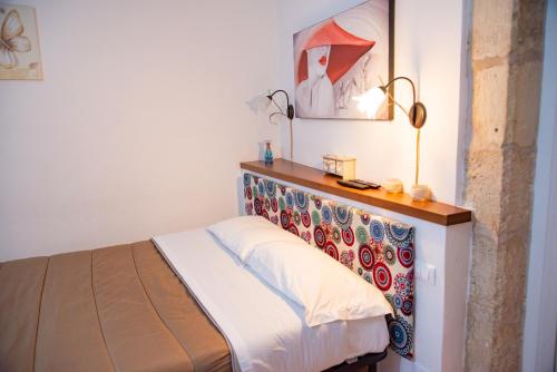 シラクーサにあるXenia - Il Vicoletto delle Deeのベッドルーム1室(木製ヘッドボード付きのベッド1台付)