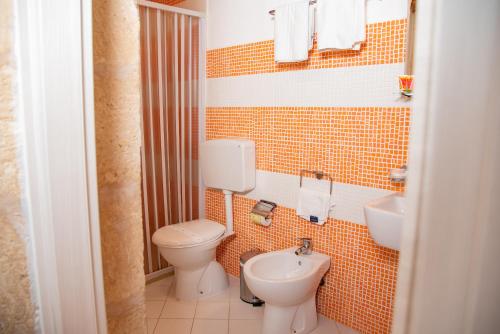 małą łazienkę z toaletą i umywalką w obiekcie Xenia - Il Vicoletto delle Dee w Syrakuzach