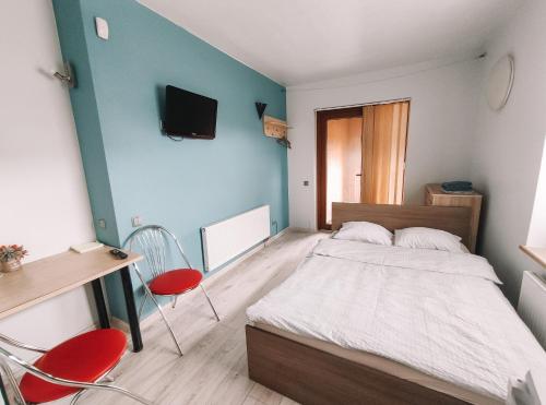 a bedroom with a bed and a desk and chairs at K-Town - Cozy Apartment Near the City Center in Kaunas