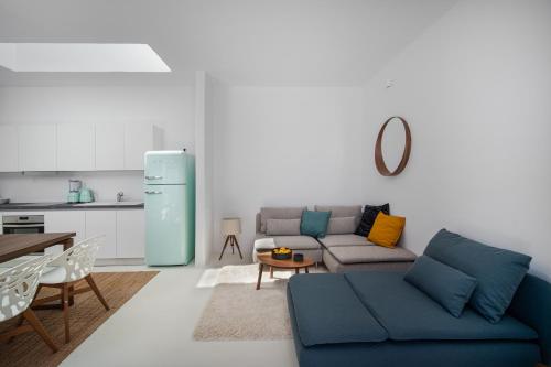 sala de estar con sofá azul y cocina en Blue Sea Villa, en Serifos Chora