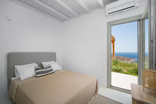 a bedroom with a bed and a large window at Blue Sea Villa in Serifos Chora