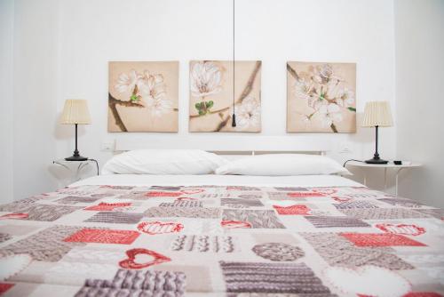 シラクーサにあるSiracusa Casa Tiche & Seleneのベッドルーム1室(壁に4つの絵画が飾られたベッド1台付)