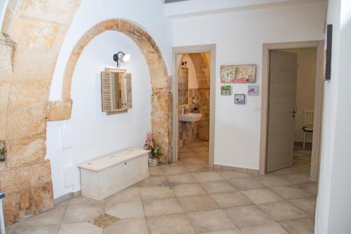 a bathroom with a tile floor and an archway at Siracusa Casa Tiche & Selene in Syracuse