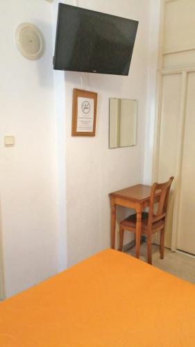 a room with a table and a chair and a television at Residencia Vale Formoso in Porto