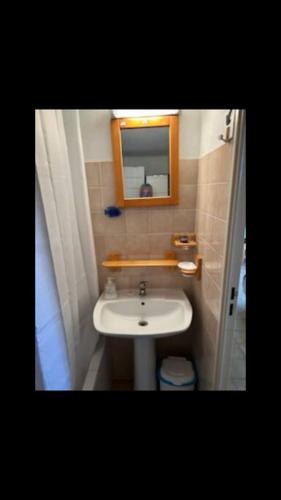 une petite salle de bain avec un lavabo et un miroir dans l'établissement Maisonnette bord de plage, à Port-Leucate