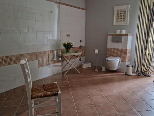 a bathroom with a toilet and a table and a chair at Beautiful Apartment in Gerdshagen near Baltic Sea Coast in Gerdshagen