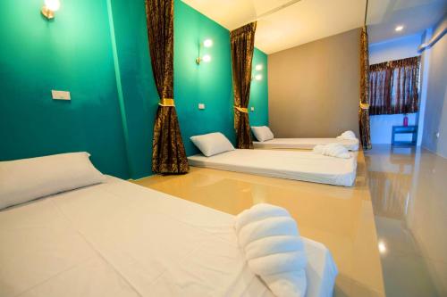 a room with two beds and a green wall at Dwella Suvarnabhumi in Lat Krabang