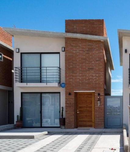 a brick building with a door and a balcony at Cómoda Villa para pasar momentos increíbles in San Carlos