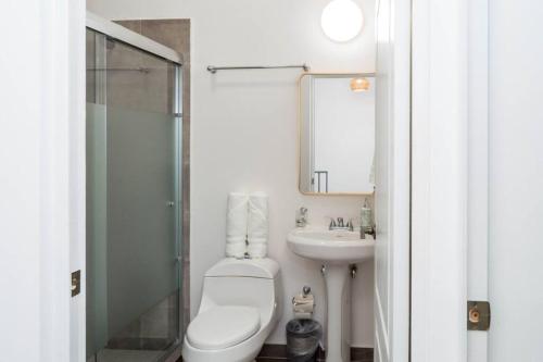 a bathroom with a toilet and a sink and a mirror at Cómoda Villa para pasar momentos increíbles in San Carlos