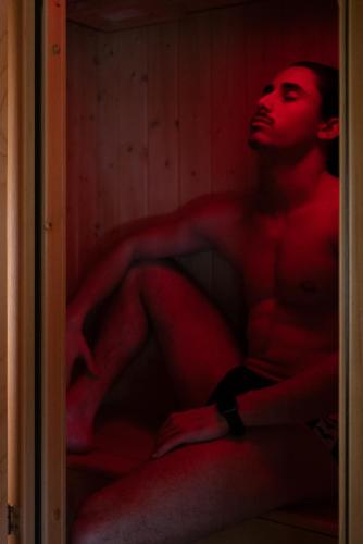 a woman sitting in a room with red lighting at Hotel Le Ortensie in Roccaraso