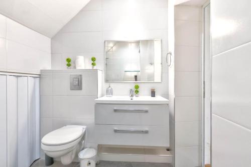 La salle de bains blanche est pourvue de toilettes et d'un lavabo. dans l'établissement Sunny 2-Bedroom Maisonette Varna & Parking, à Varna