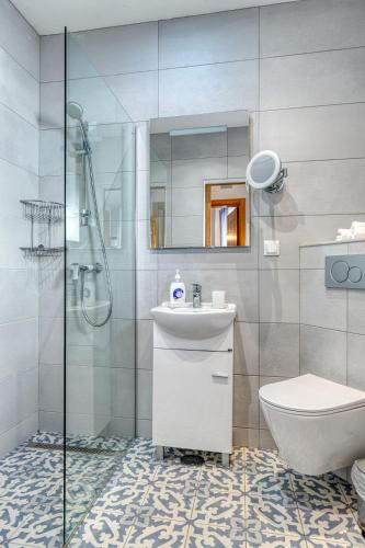 a bathroom with a shower and a sink and a toilet at Casa Perola -ocean view cottage in Carvoeiro