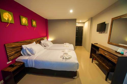 a bedroom with a large bed with a red wall at Dwella Suvarnabhumi in Lat Krabang