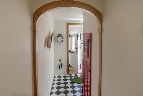 une arche menant à un couloir avec un sol en damier dans l'établissement TikLiving, à Ericeira