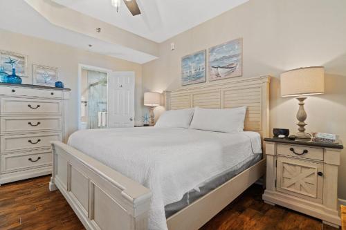 a bedroom with a large white bed and a dresser at Phoenix Vll 1102 in Orange Beach