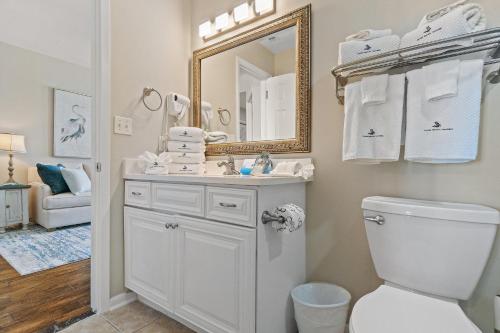 a bathroom with a toilet and a sink and a mirror at Phoenix Vll 1102 in Orange Beach