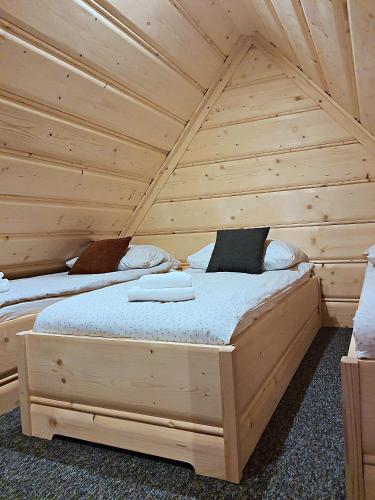 a bedroom with two beds in a log cabin at Apartamenty u Pietrka in Kościelisko