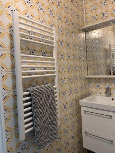 La salle de bains est pourvue d'un lavabo et d'une serviette. dans l'établissement appartement catimini, à Dijon
