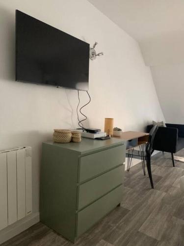 Cette chambre dispose d'une commode et d'une télévision murale. dans l'établissement appartement catimini, à Dijon