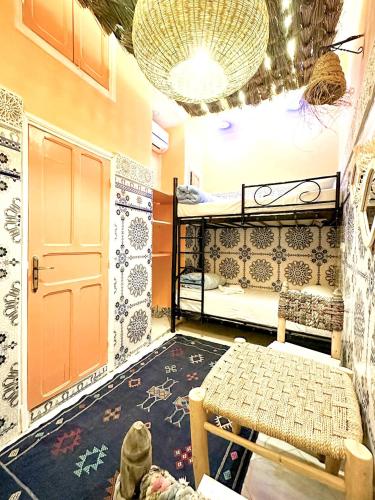 a dorm room with two bunk beds and a table at Riad Verus in Fès