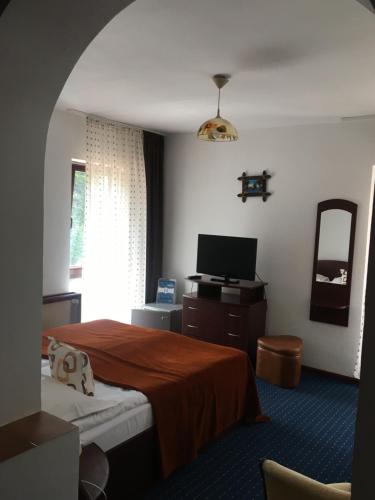 a hotel room with a bed and a television at Ancora in Predeal