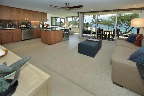 a living room with a couch and a kitchen at The Hale Pau Hana in Kihei