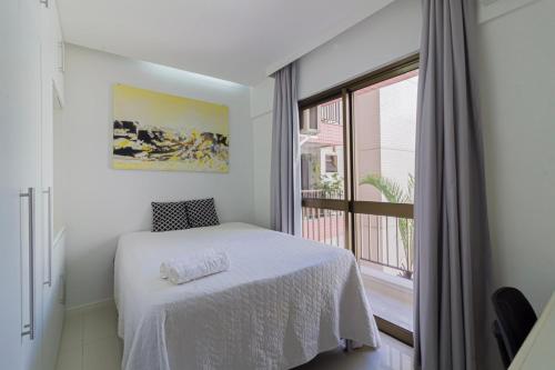 een slaapkamer met een wit bed en een raam bij Lobie Ipanema Barão da Torre in Rio de Janeiro