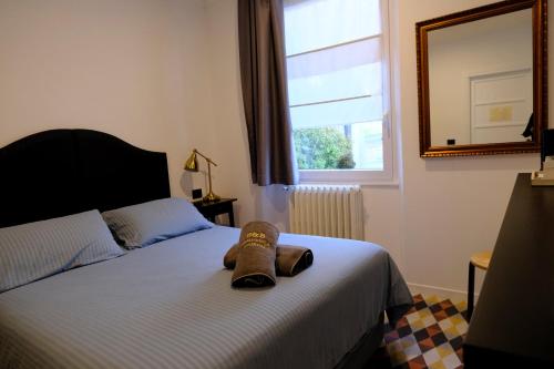 a bedroom with a bed with a pair of shoes on it at Residenza Laurum in Mandello del Lario