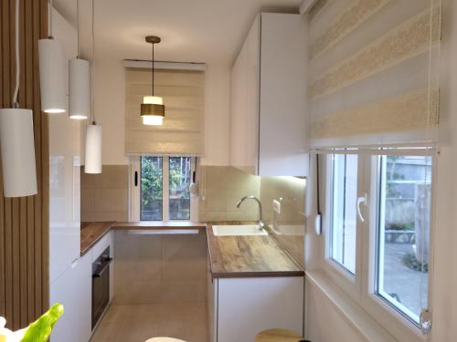 a kitchen with white cabinets and a sink and a window at Holiday home Paula in Radovići