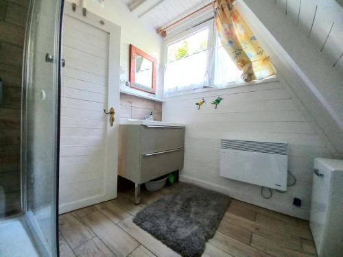 ein Bad mit einem Waschbecken, einer Dusche und einem Fenster in der Unterkunft Domek letniskowy Pirat in Mrzeżyno