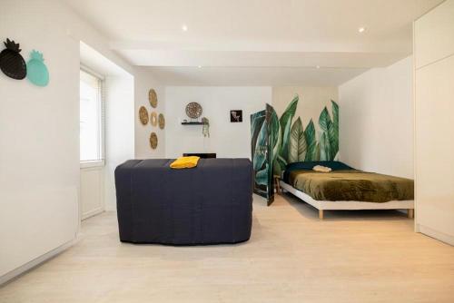 una camera con un letto e un pouf blu in una stanza di Le p’tit nid des Halles a Le Grand-Lemps