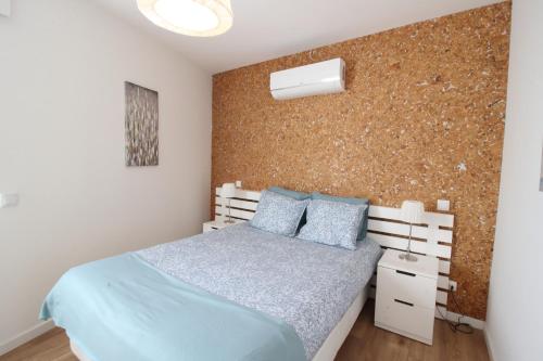 - une chambre avec un lit et un mur en briques dans l'établissement Downtown Villa, à Faro