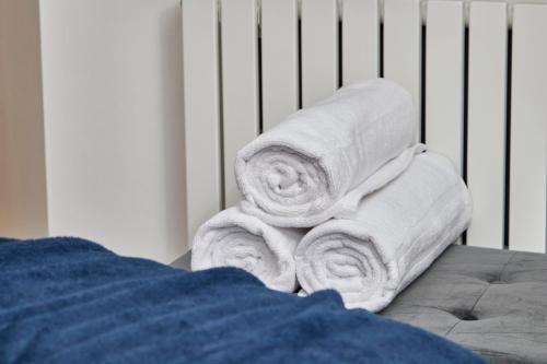 a stack of towels sitting in a crib at Beautiful House in Manchester Sleeps 8 Inc Parking in Wythenshawe