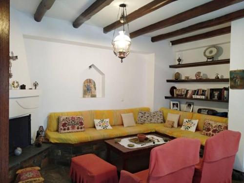 a living room with a yellow couch and a table at Melina's Mansion in Tsagarada