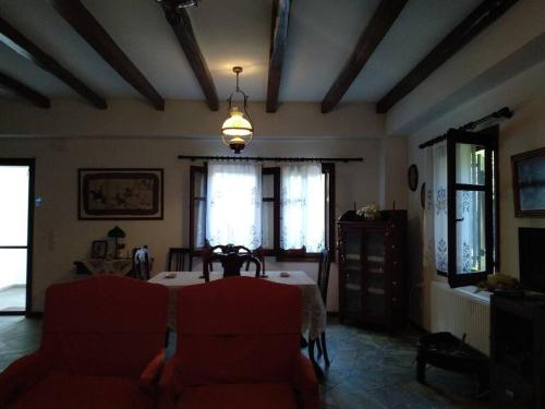 a living room with a table and red chairs at Melina's Mansion in Tsagarada