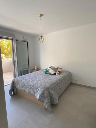 une chambre avec un lit dans une pièce blanche dans l'établissement Le Soleil de Mougins, à Mougins
