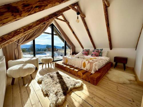 a bedroom with a bed and a large window at Casuta din Balcesti in Bălceşti