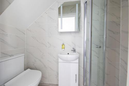 bagno bianco con servizi igienici e lavandino di Anson Hotel Modern And Spacious Loft Suite a Londra