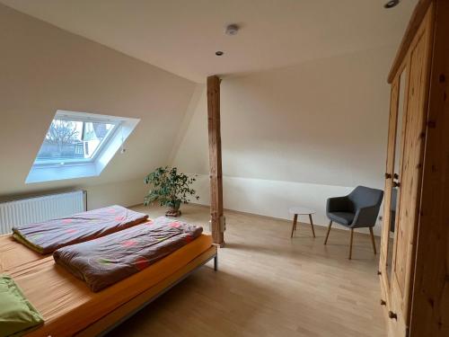 een slaapkamer met een bed, een stoel en een raam bij Berufspendler- wohnen wo Andere Urlaub machen in Neuhütte