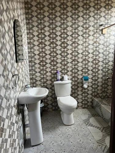 a bathroom with a toilet and a sink at Stunning Executive 2 Bedroom Apartment with KING SIZE BED in Kumasi