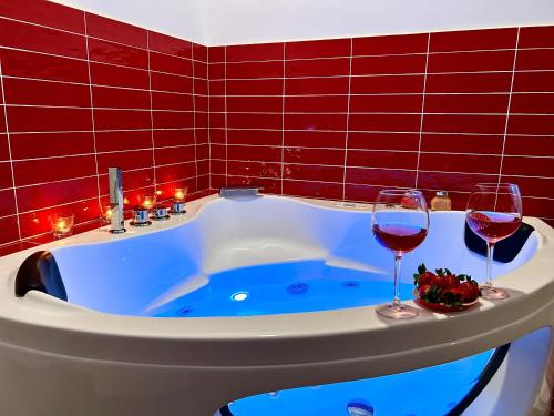 - deux verres de vin assis sur une baignoire dans l'établissement B&B Easy, à Rome