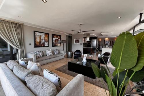 uma grande sala de estar com um sofá e uma mesa em Luxury Penthouse In The Heart Of Sandton em Joanesburgo