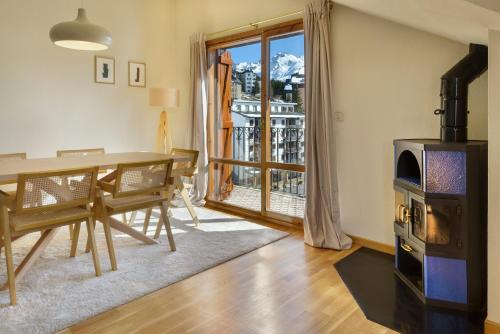 a dining room with a table and a wood stove at Montesqui Formigal, exclusivo ático con vistas a pistas, guardaesquis y garaje in Formigal